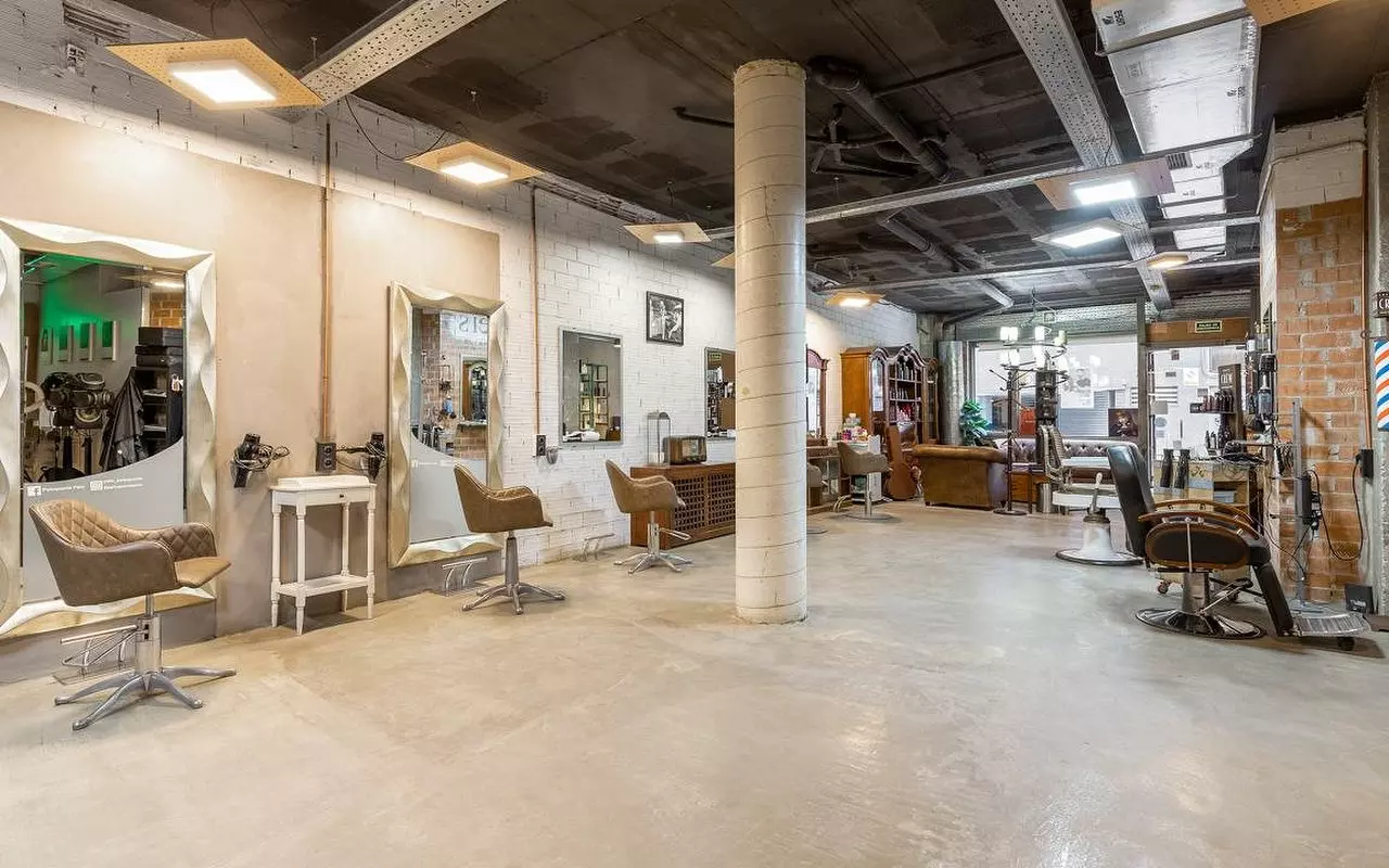 Peluquero corta el pelo a un persona.