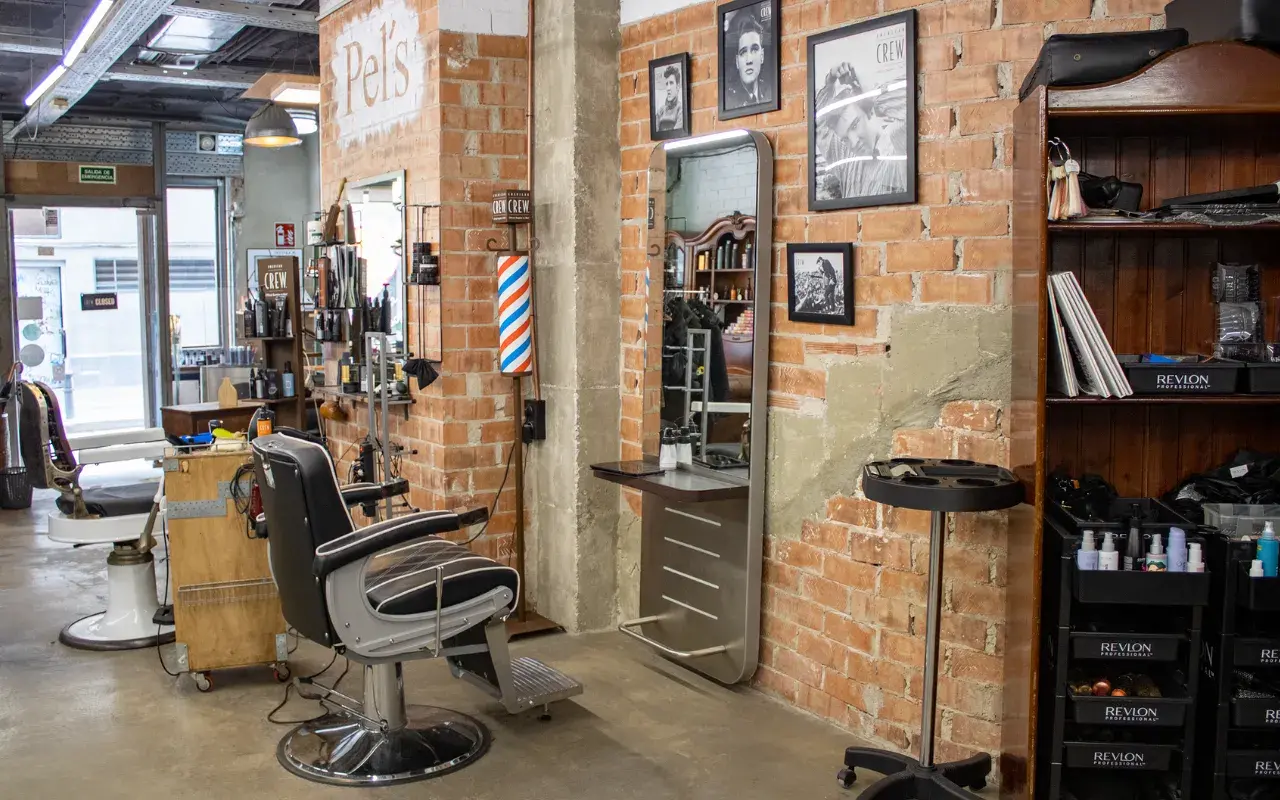 Peluquero corta el pelo a un persona.